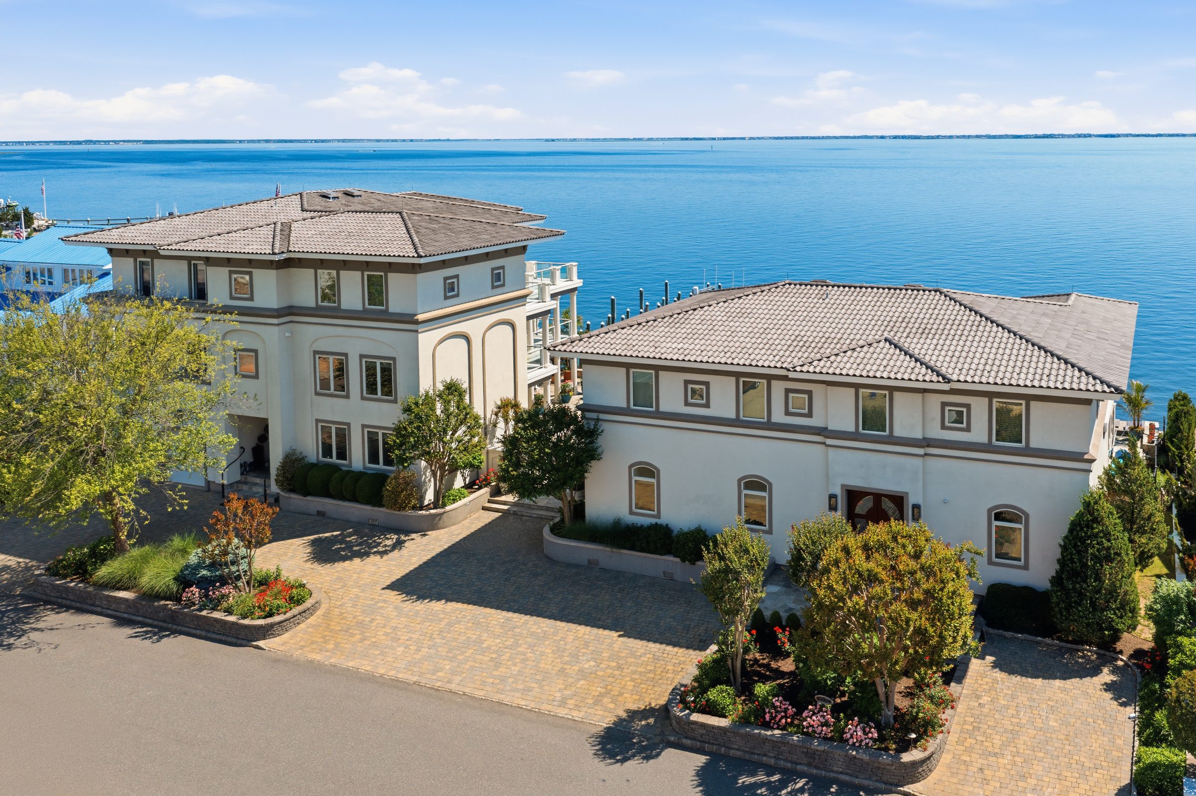 aerial view of the main residence and guest house showing the paver driveway and landscaped grounds