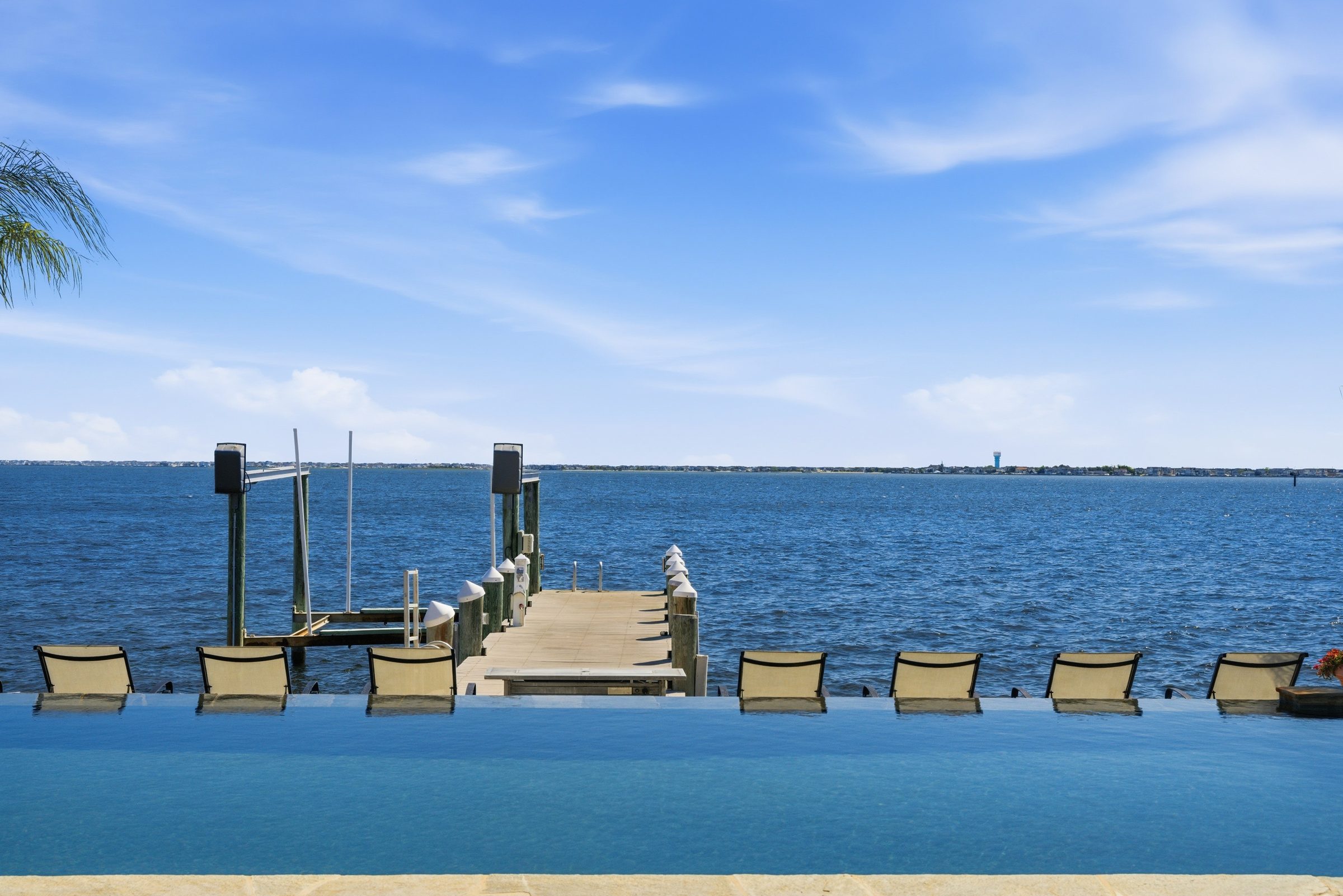 infinity pool and dock lounge chairs overlooking the water