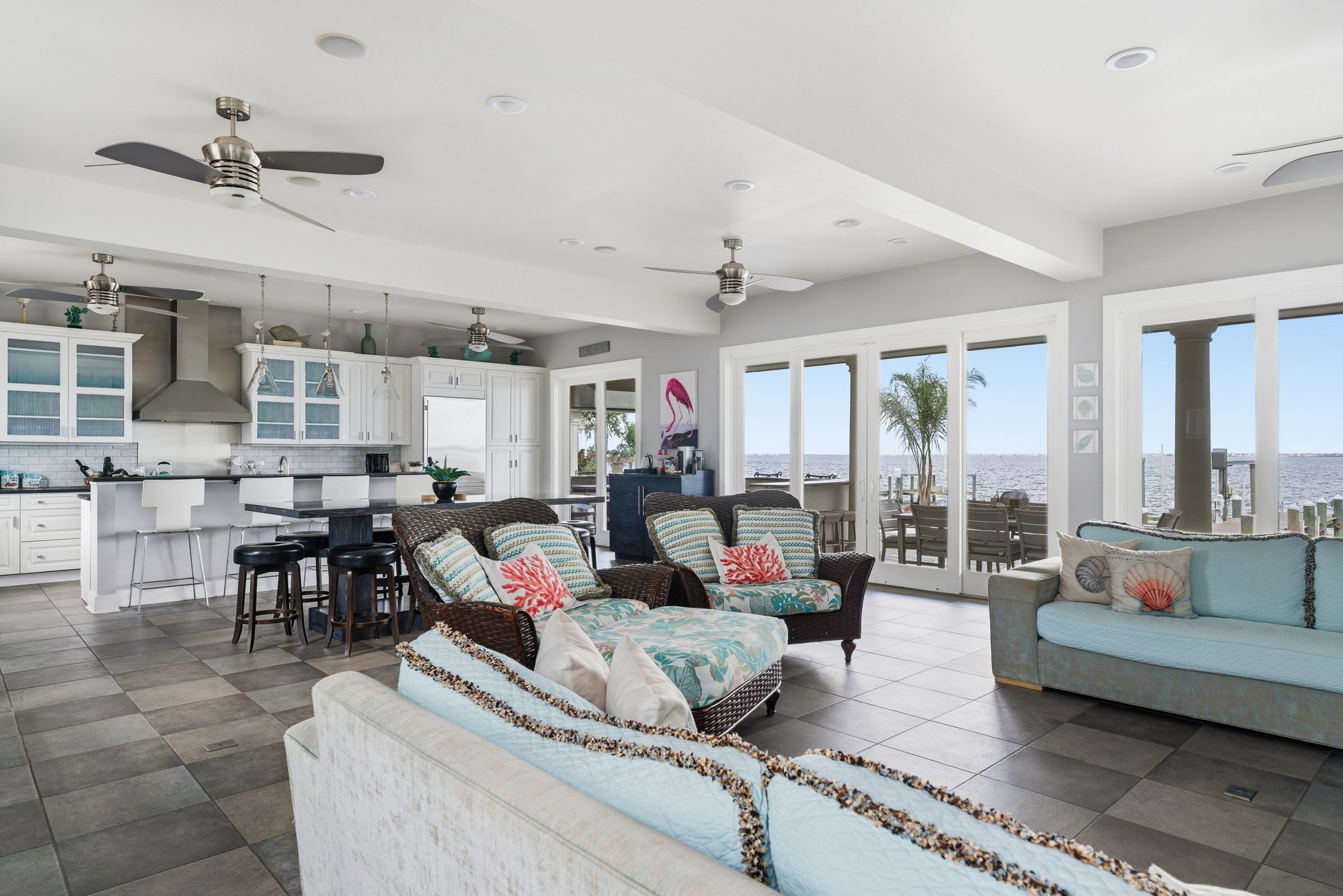 open-concept guest house kitchen, dining and living area with full water views through French doors