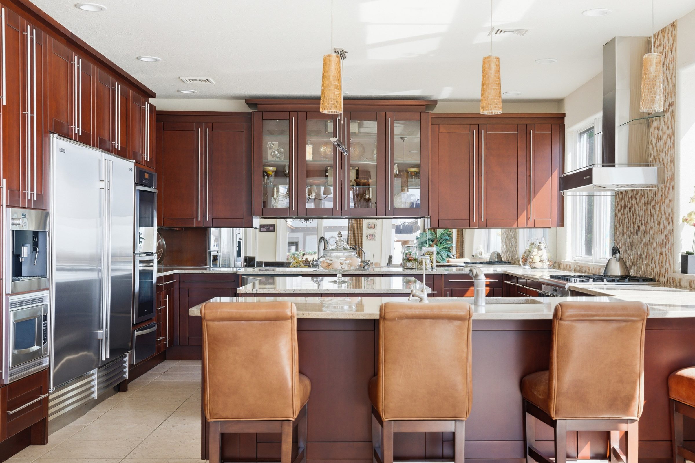 kitchen breakfast bar with leather stools and water views through the window