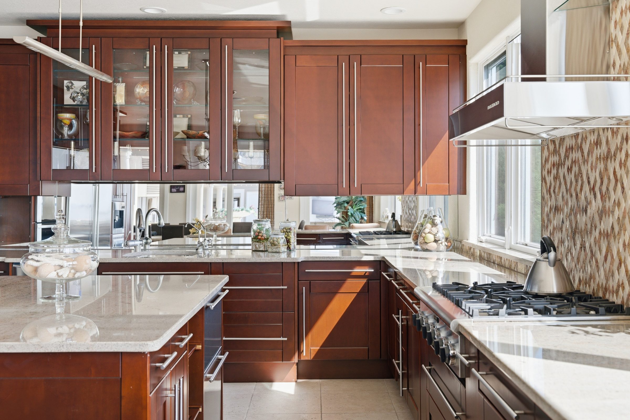 kitchen island with glass cabinetry and mirrored backsplash