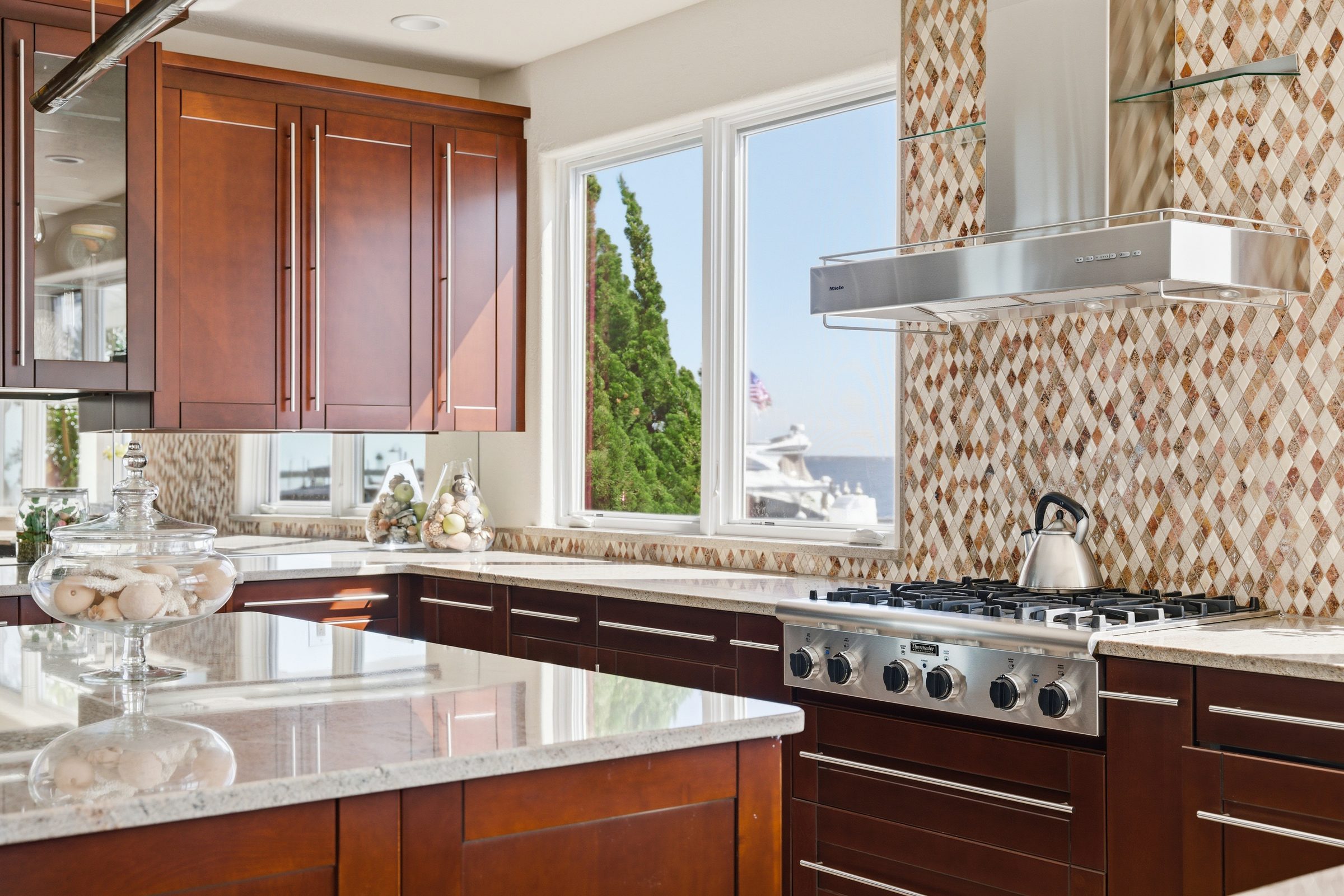 gas range with mosaic backsplash and a view of the water and boats