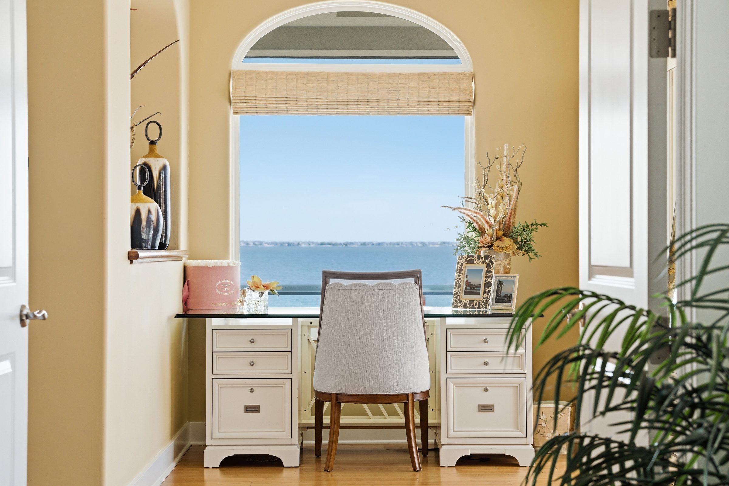 primary suite lounge area with desk and floor-to-ceiling window overlooking the water