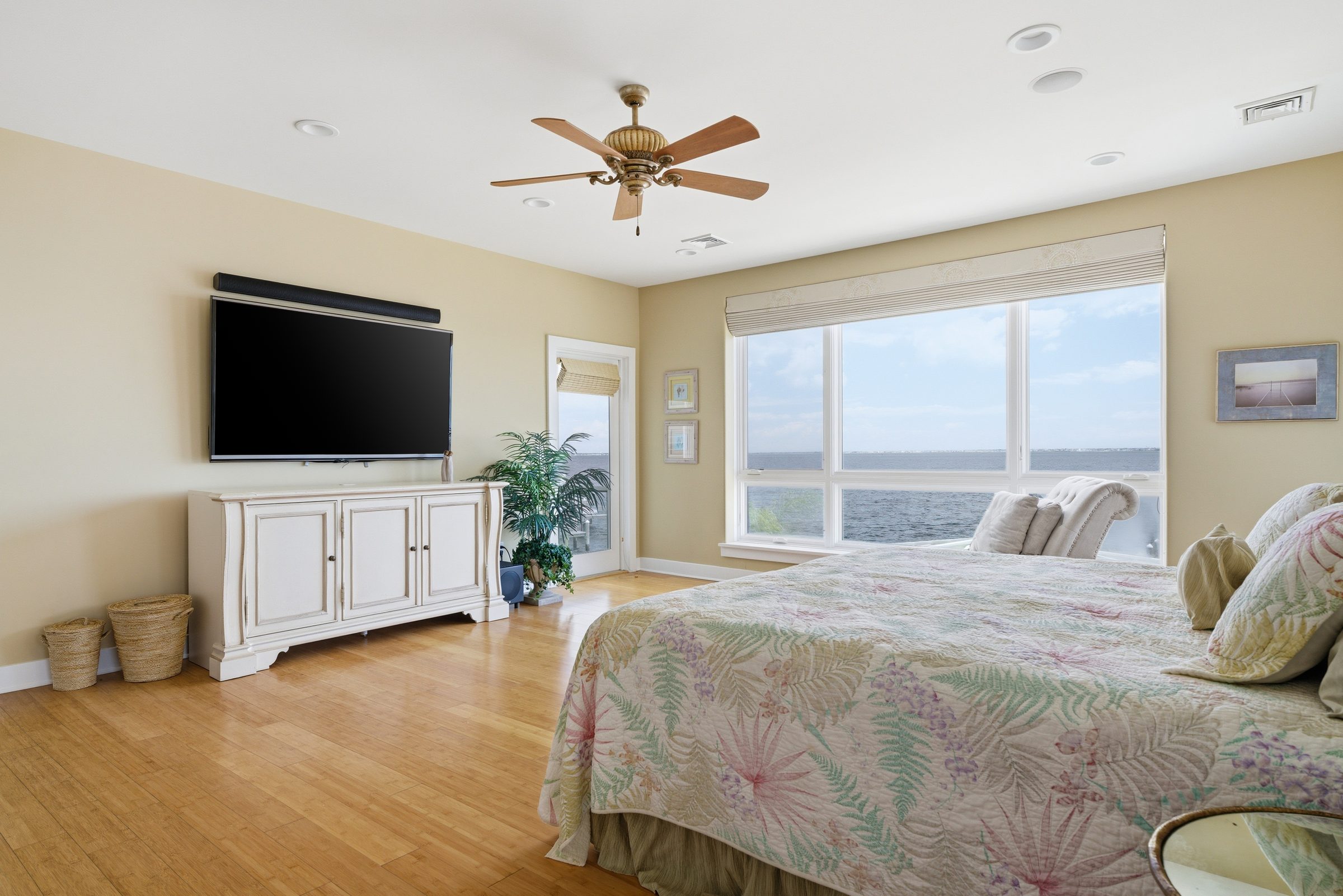 primary bedroom with television, white dresser and floral bedding