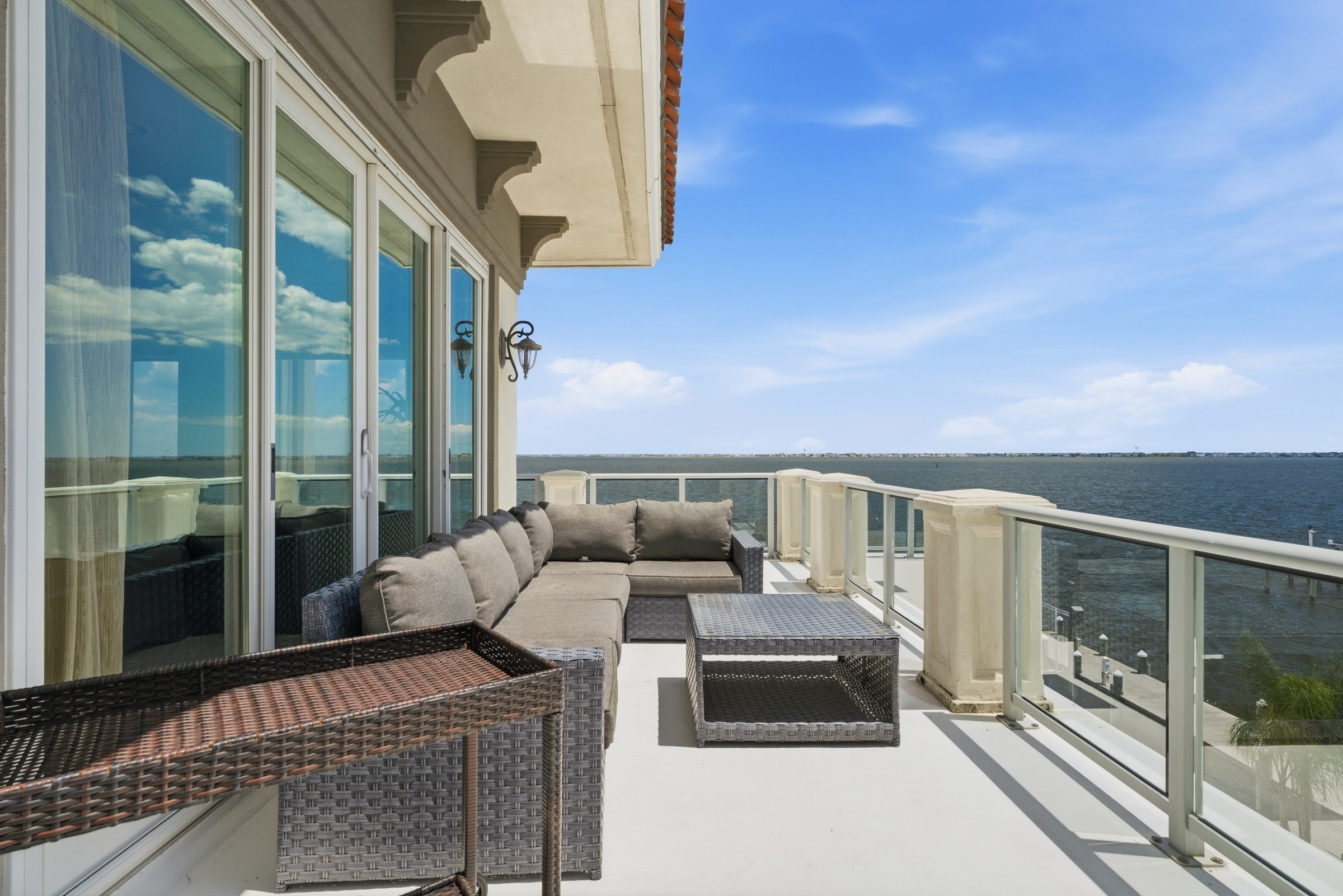 covered wraparound third-floor balcony furnished with wicker seating