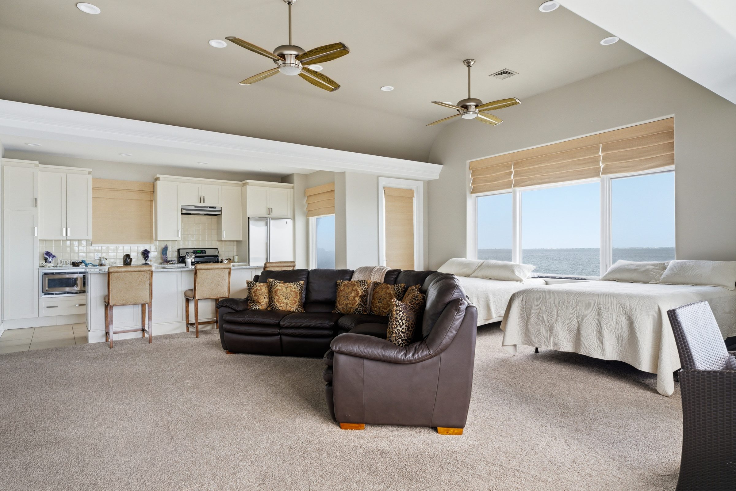 third-floor loft with kitchenette, sectional seating and water views